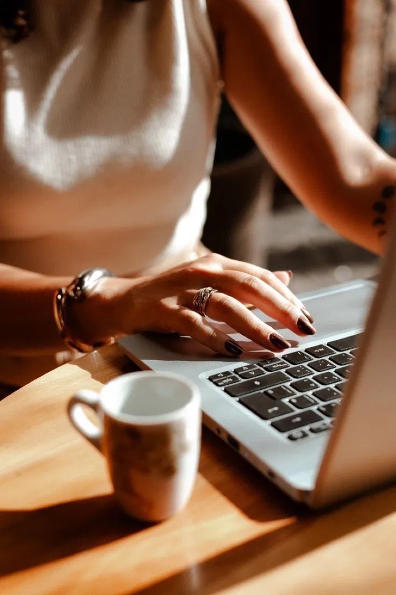 Mulher trabalhando no notebook com uma xícara de café