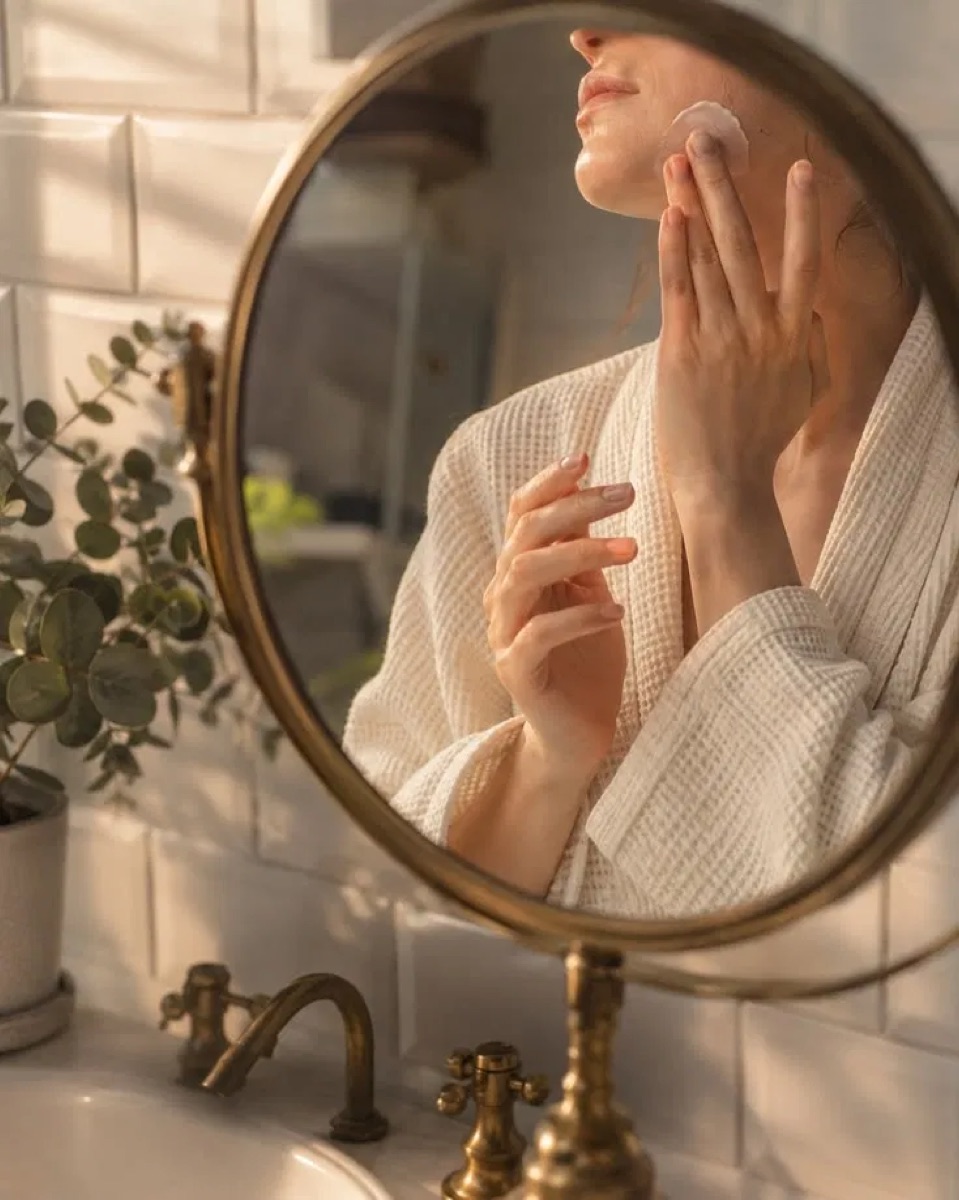 Mulher fazendo skincare em frente ao espelho